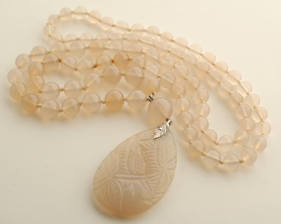 Appraisal: A Carved Chalcedony Pendant and Bead Necklace the off white