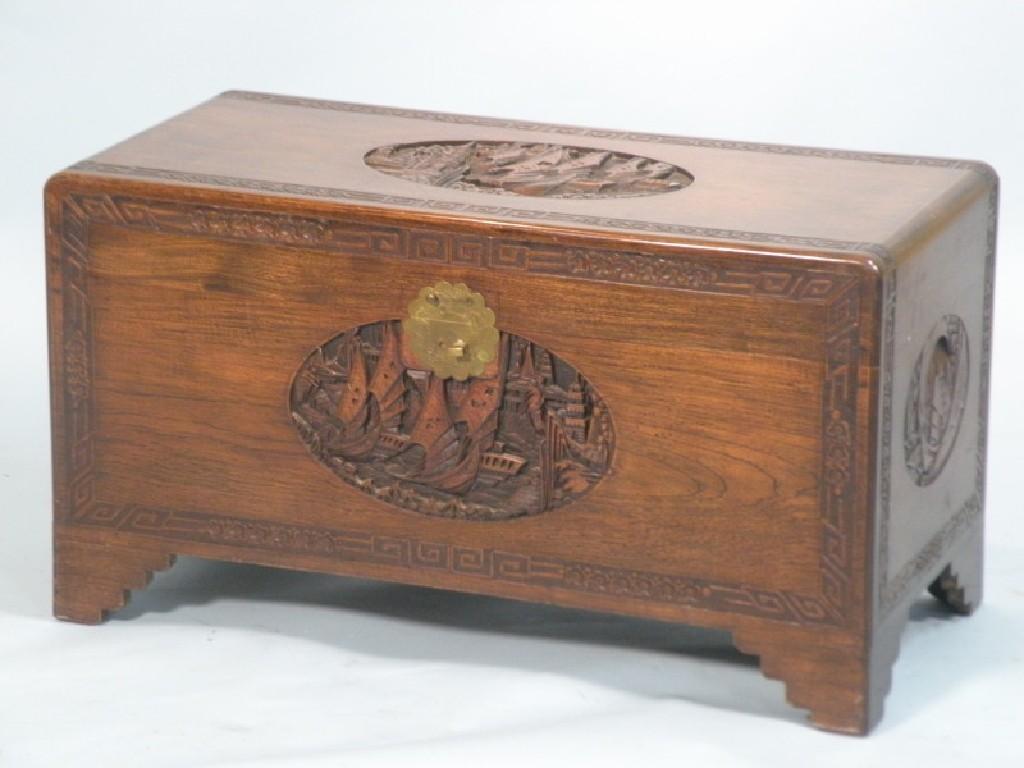 Appraisal: An Eastern caved camphor wood chest decorated with ships and