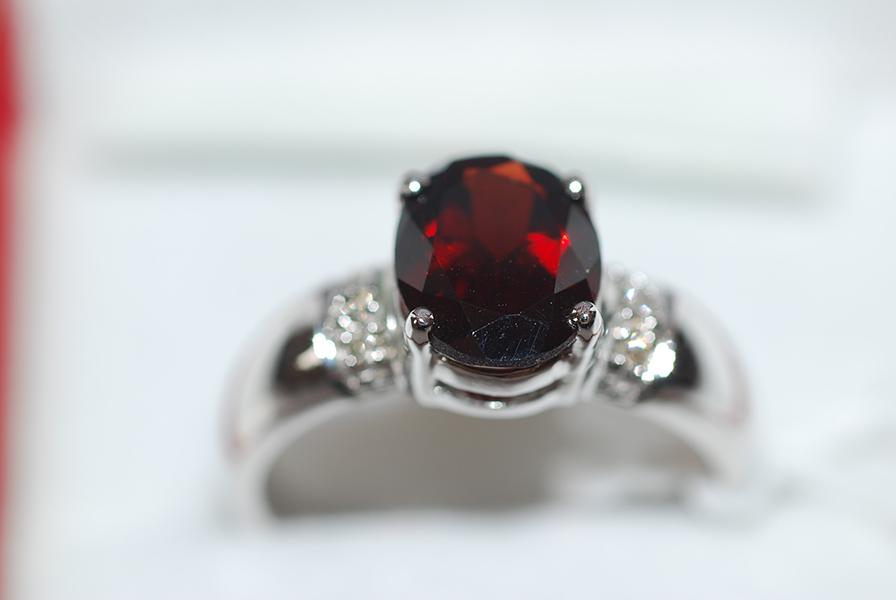 Appraisal: A GARNET AND DIAMOND DRESS RING IN CT WHITE GOLD