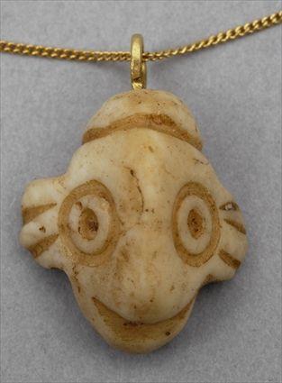 Appraisal: WHITE STONE FACE PENDANT ON GOLD CHAIN Simple stylized head