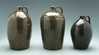 Appraisal: Three stoneware jugs runny dark olive alkaline glaze possibly North