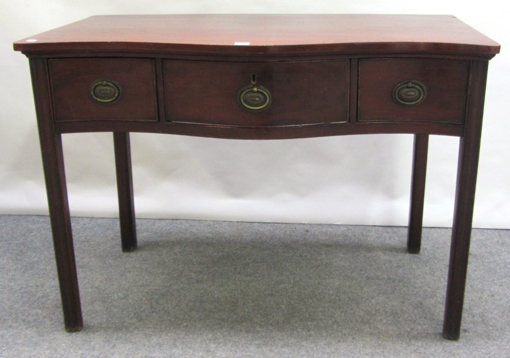 Appraisal: An th century mahogany serpentine three drawer side table on