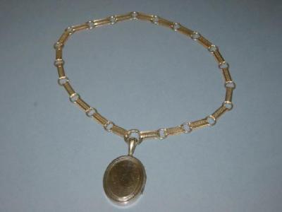 Appraisal: A VICTORIAN SILVER LOCKET of oval form with engine turned