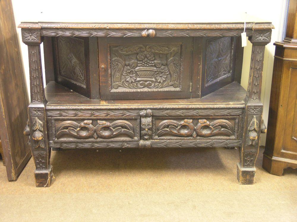 Appraisal: A Victorian dark carved oak buffet angled cupboard flanked by