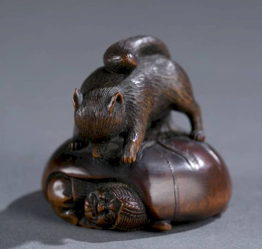 Appraisal: Japanese wood netsuke of tanuki and shoki A Japanese wood