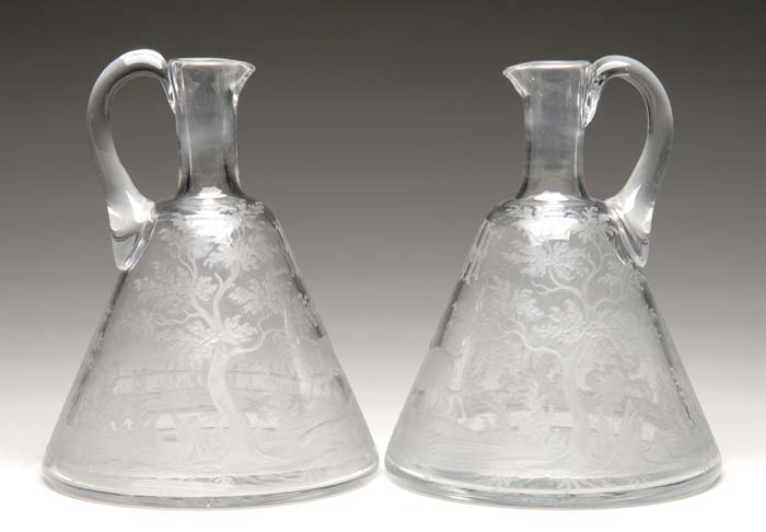 Appraisal: PAIR OF BOHEMIAN ENGRAVED EWERS Engraved decoration consists of a