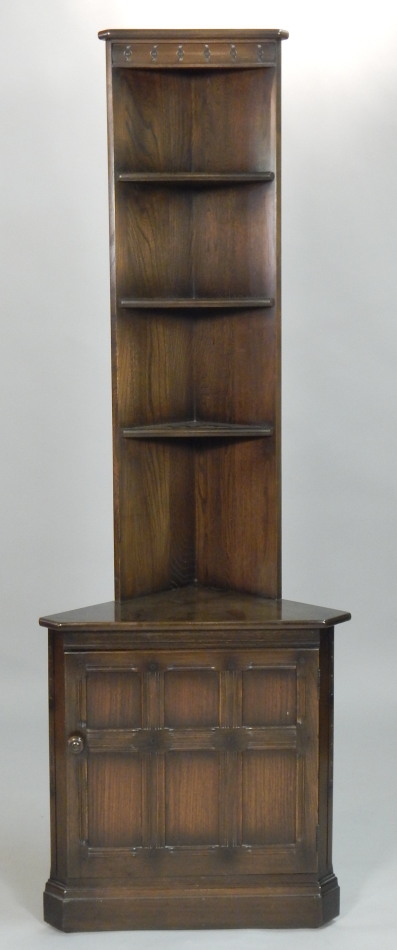 Appraisal: An Ercol dark elm corner cabinet with open shelves to