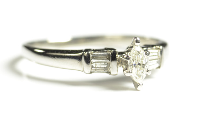 Appraisal: DIAMOND AND FOURTEEN KARAT WHITE GOLD RING with two baguette-cut