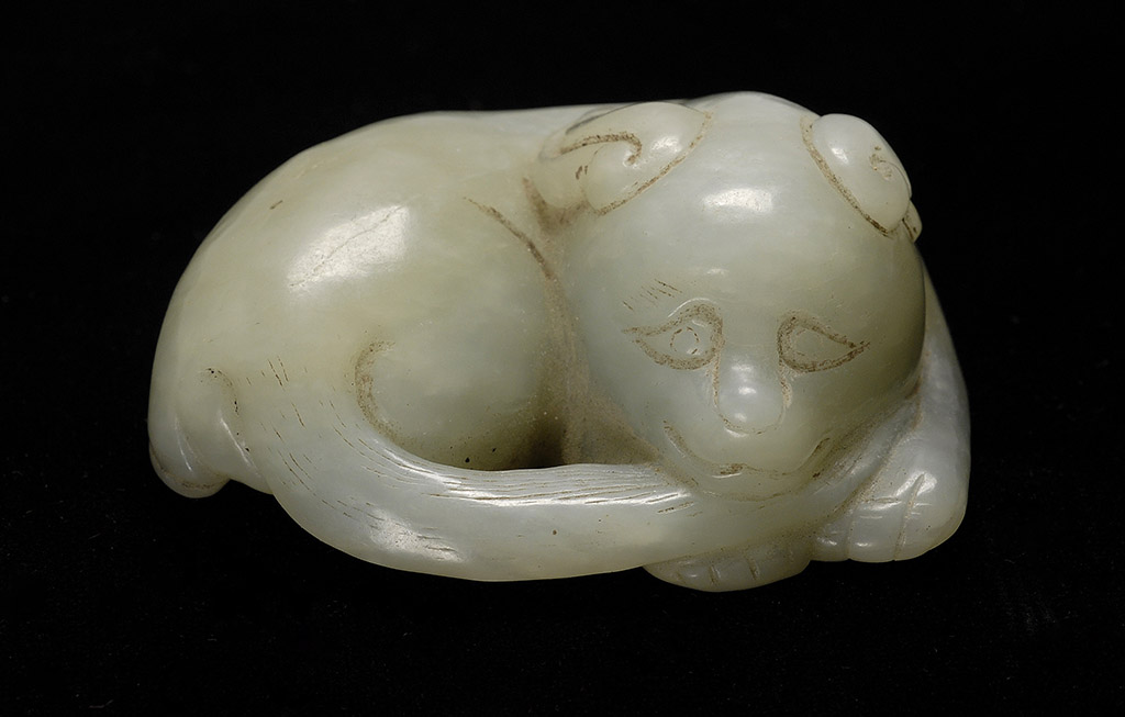 Appraisal: WHITE JADE CARVING In the form of a reclining dog