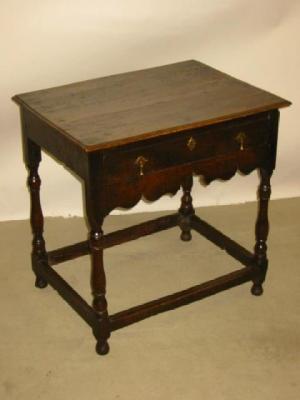 Appraisal: AN OAK SIDE TABLE with moulded edged top waved frieze