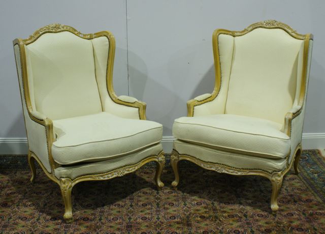 Appraisal: A pair of carved beech and upholstered wingback armchairs in