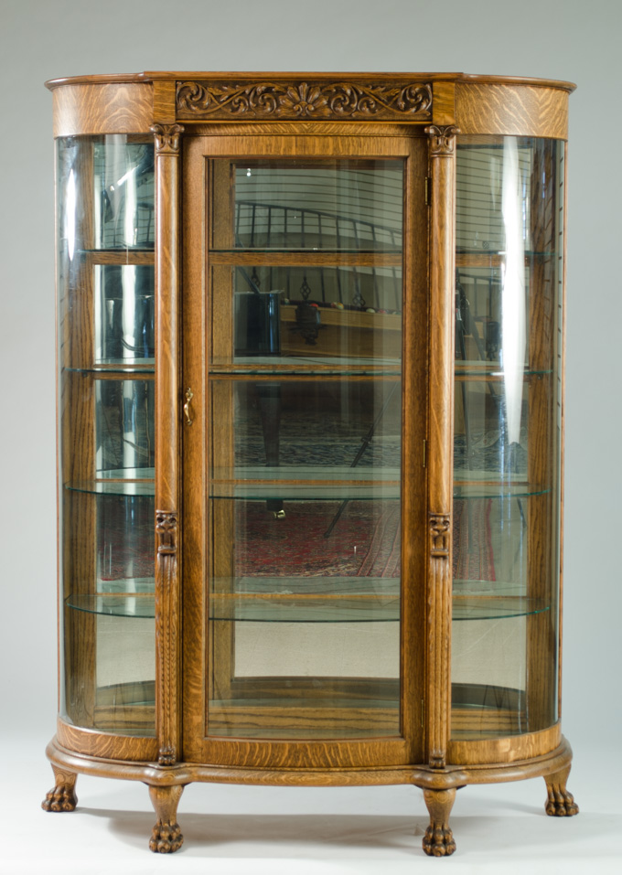 Appraisal: CARVED OAK AND CURVED GLASS CHINA DISPLAY CABINET American c