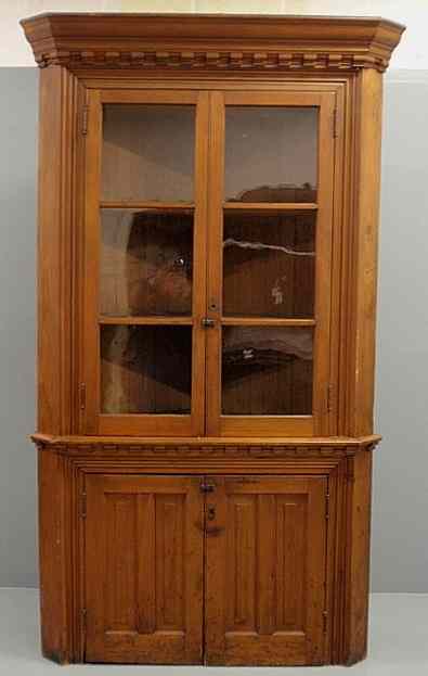 Appraisal: Pine one-piece corner cupboard with a molded cornice above two