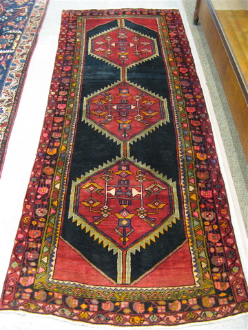 Appraisal: PERSIAN TRIBAL HALL RUG featuring three hexagonal pole medallions on