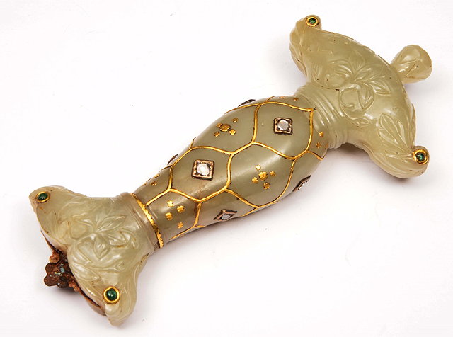 Appraisal: A MUGHAL JADE DAGGER HILT studded with uncut diamonds rubies