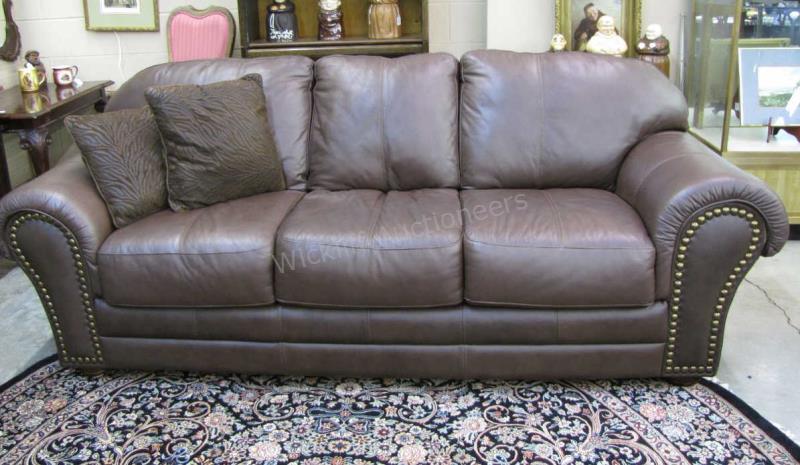 Appraisal: A decorator-quality sofa brown leather with nailhead trim bun foot