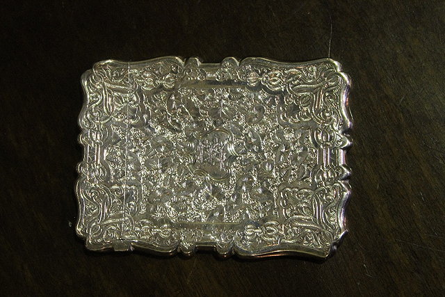 Appraisal: A SILVER CARD CASE of stylised form with profuse engraved