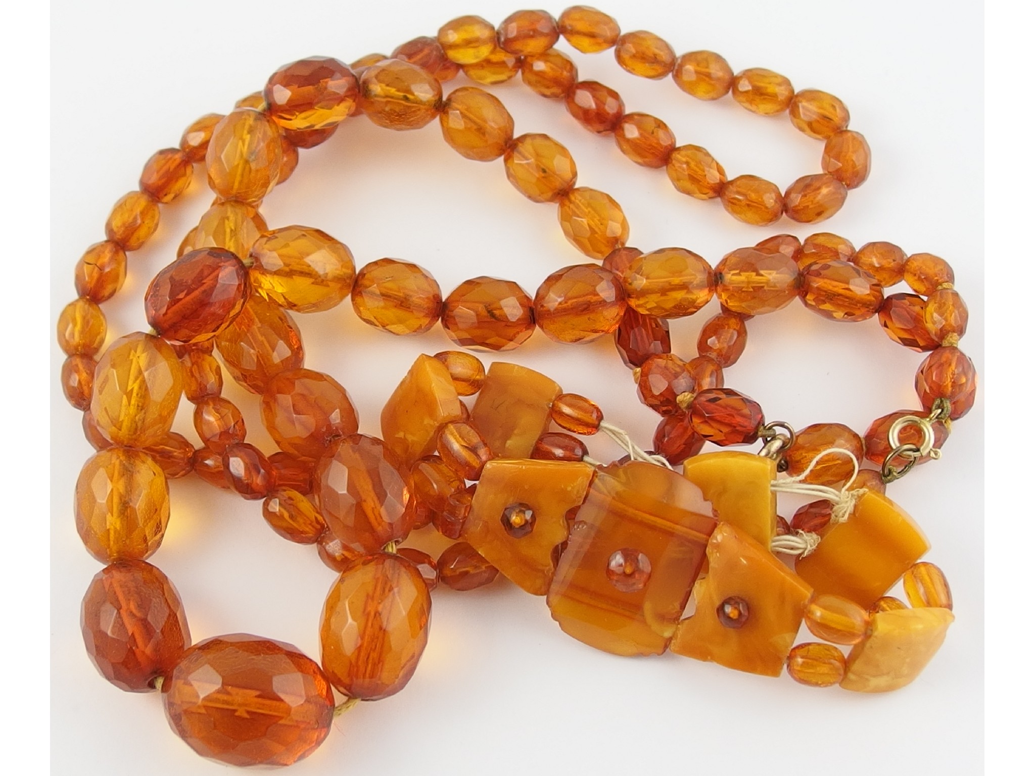 Appraisal: Two clear faceted orange amber necklaces and an opaque and