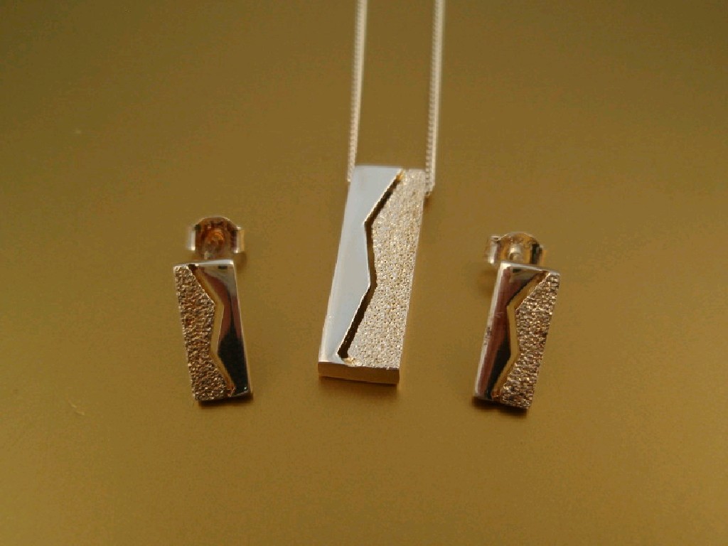 Appraisal: A contemporary style pendant and matching earrings in white metal