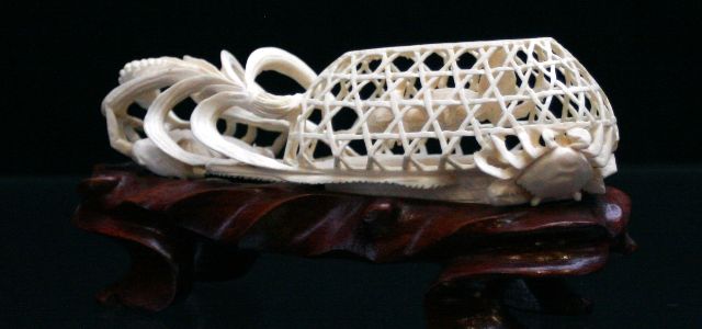 Appraisal: An ivory carving of a crabtrap on a wooden stand