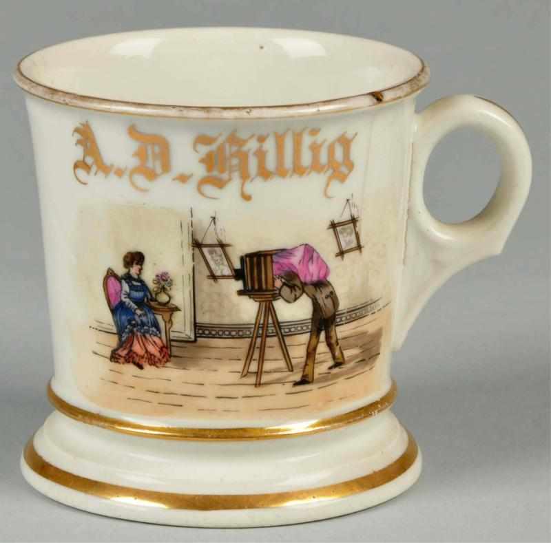 Appraisal: Photographer with Old Portrait Camera Shaving Mug Description Gilt name