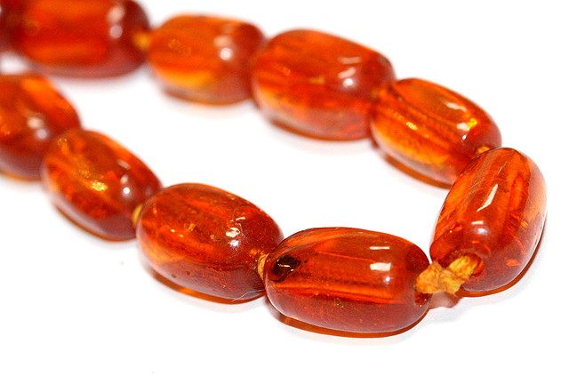 Appraisal: AN AMBER BEAD NECKLACE oval beads largest mm wide x