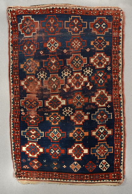 Appraisal: AN ANTIQUE CAUCASIAN BLUE GROUND RUG decorated four rows of