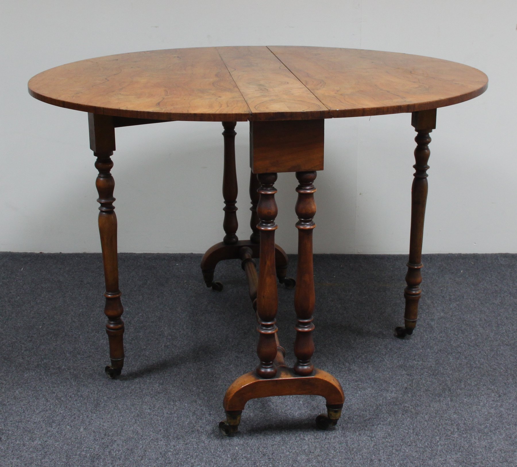 Appraisal: A Victorian walnut Sutherland table the oval two-flap top on