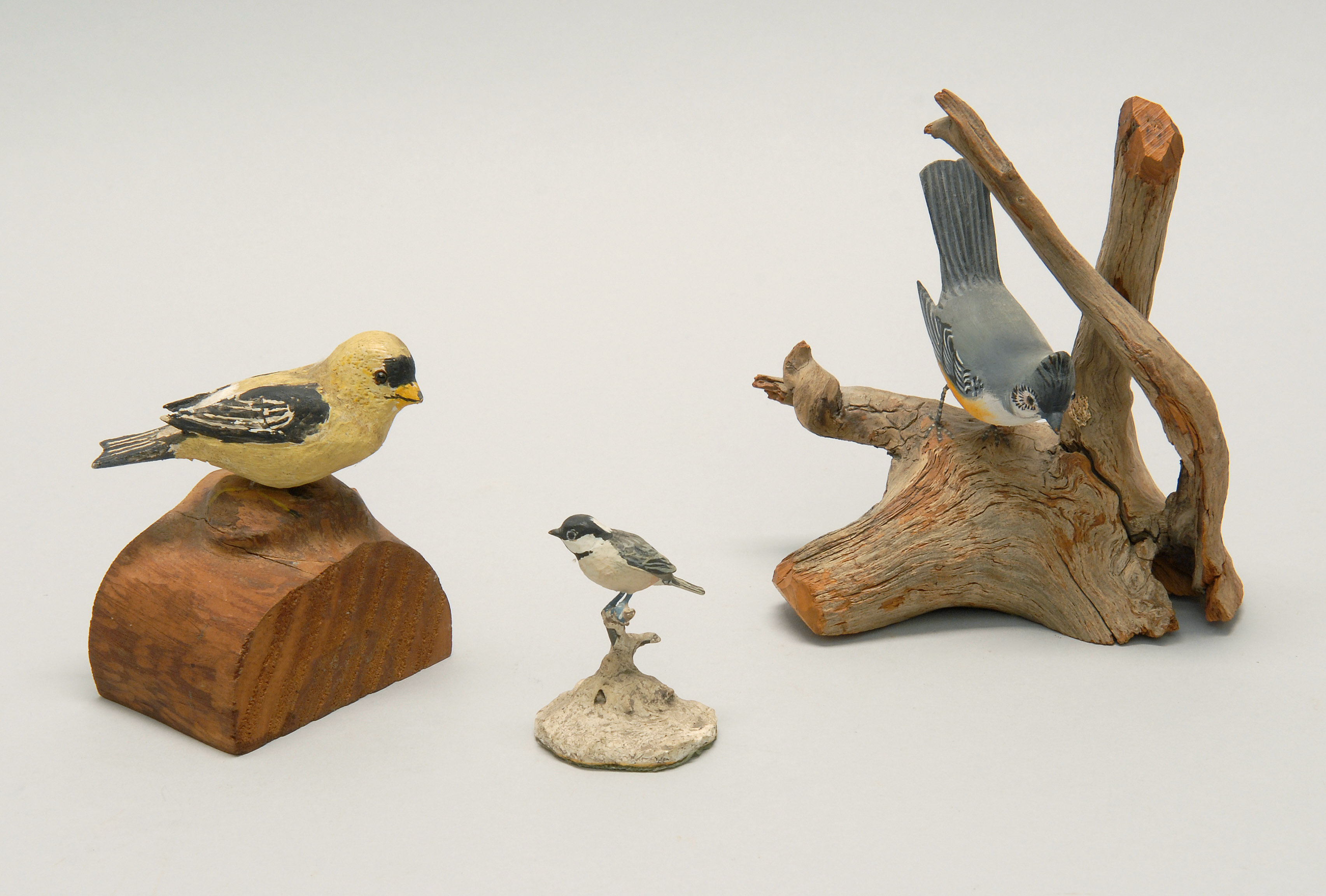 Appraisal: THREE DECORATIVE BIRD CARVINGS A yellow goldfinch marked on underside