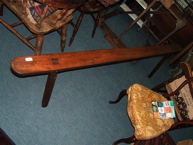 Appraisal: A narrow antique wooden bench standing on four legs wide