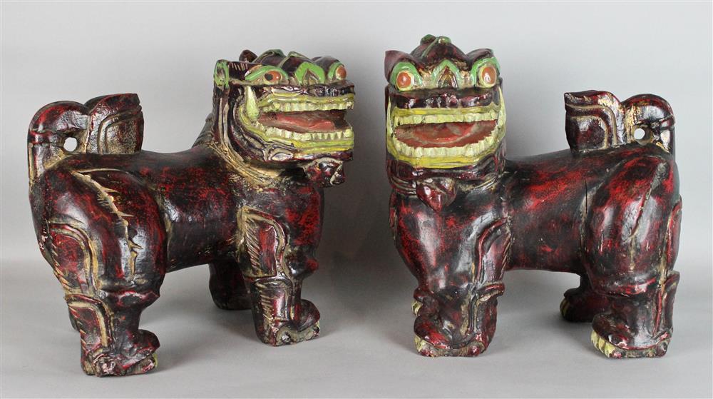 Appraisal: PAIR OF PAINTED WOOD BUDDHISTIC LIONS standing in characteristic poses