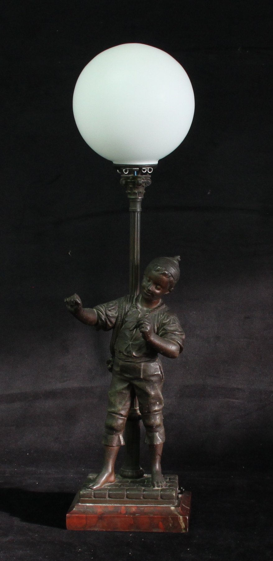 Appraisal: A spelter lamp base modelled as a boy lighting a