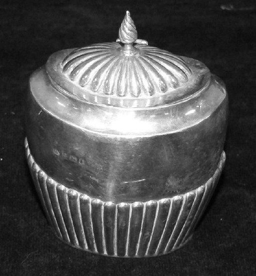 Appraisal: An oval half ribbed tea caddy with hinged cover and