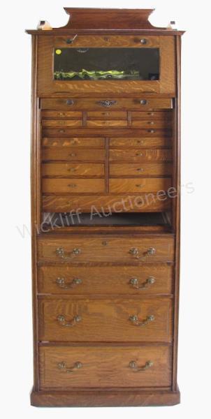 Appraisal: An antique oak dental cabinet with multiple instrument doors tambour