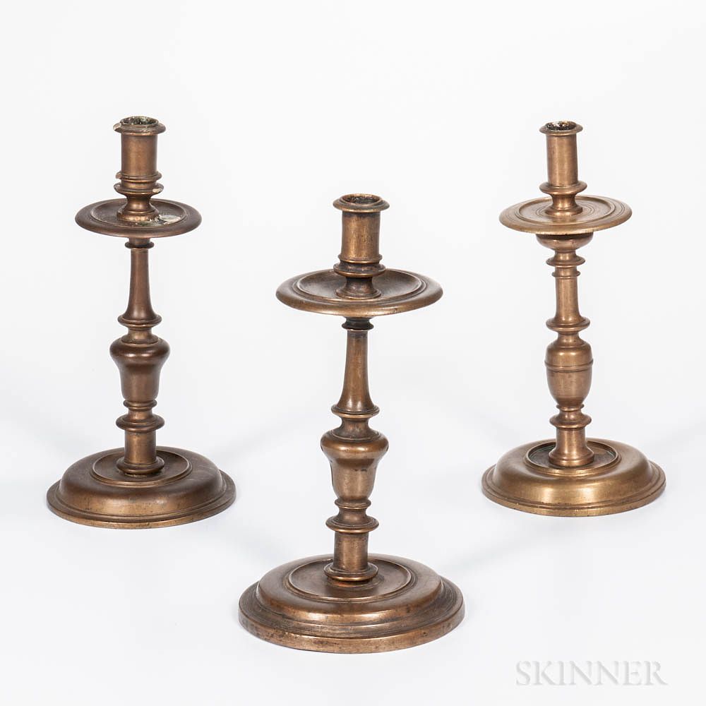 Appraisal: Three Tall Early Brass Candlesticks Three Tall Early Brass Candlesticks