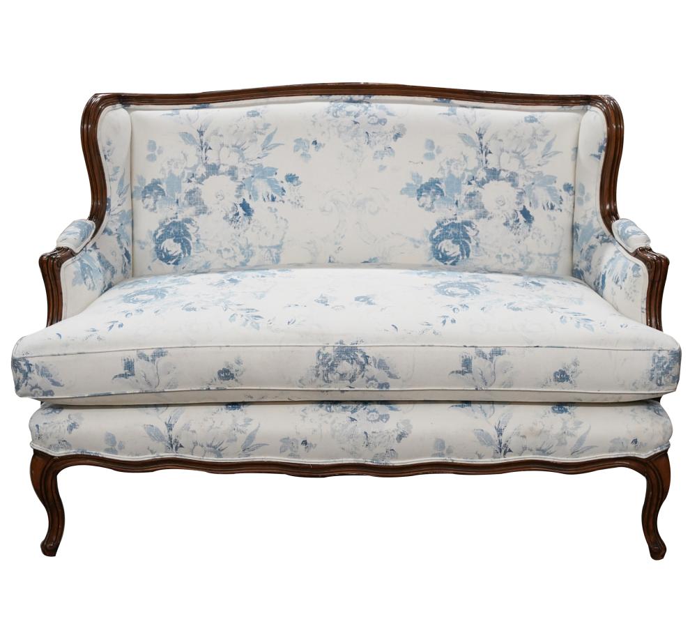 Appraisal: FRENCH PROVINCIAL STYLE SETTEEcovered with blue and white floral-printed fabric