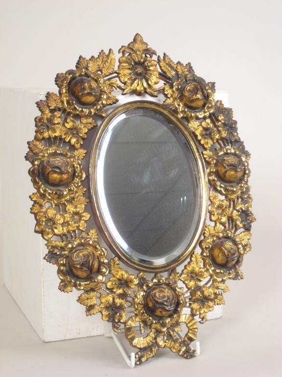 Appraisal: A cast gilt metal oval Mirror with bevelled plate and