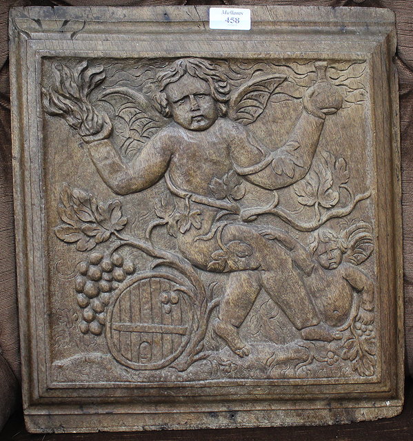 Appraisal: AN ANTIQUE CARVED WALNUT PANEL depicting cherubs cm x cm