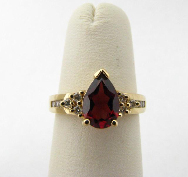 Appraisal: K yellow gold ring with pear shaped garnet and twelve