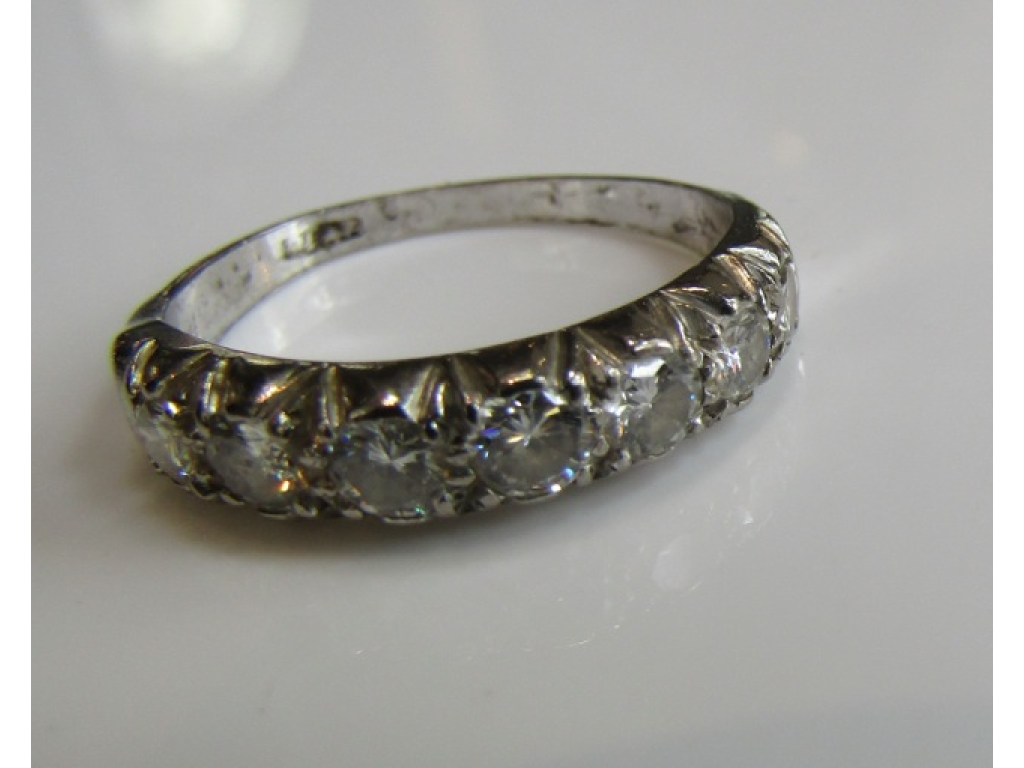 Appraisal: A diamond ring set with seven graduated round brilliant-cut diamonds