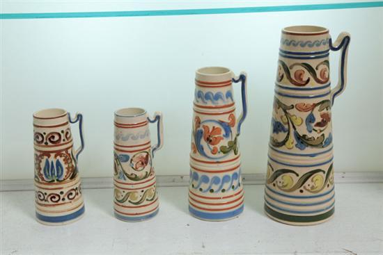 Appraisal: FOUR ENGLISH POTTERY PITCHERS Torquay type handled pitchers banded with