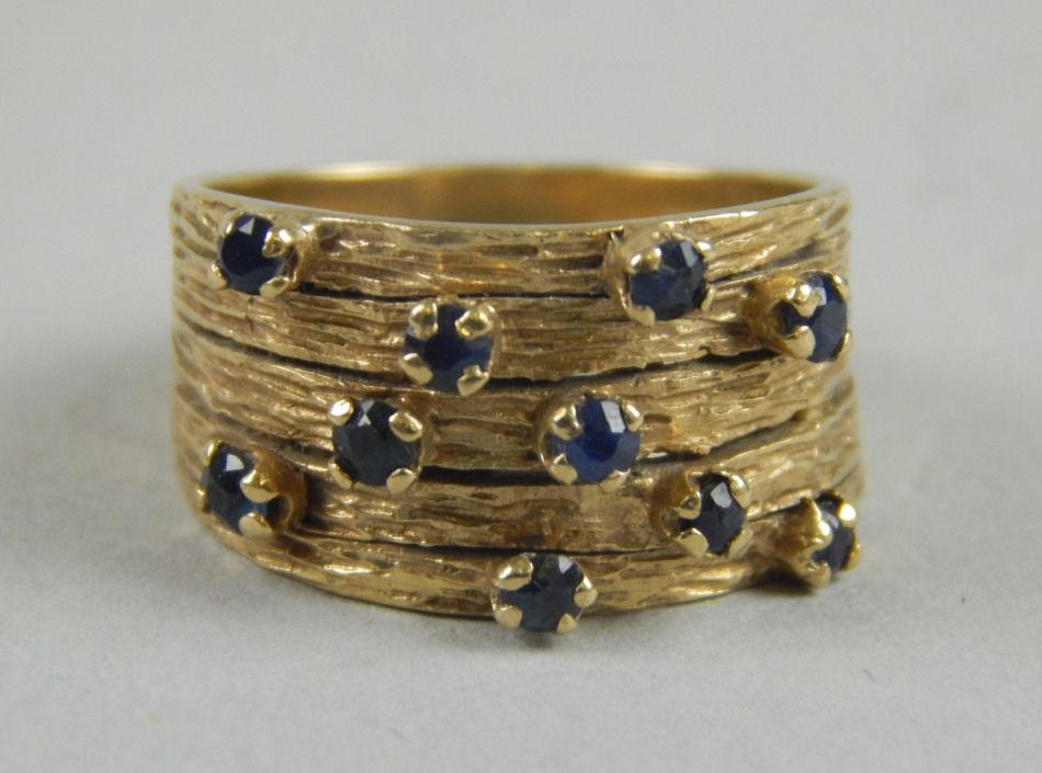 Appraisal: A modern abstract dress ring set with blue stones yellow