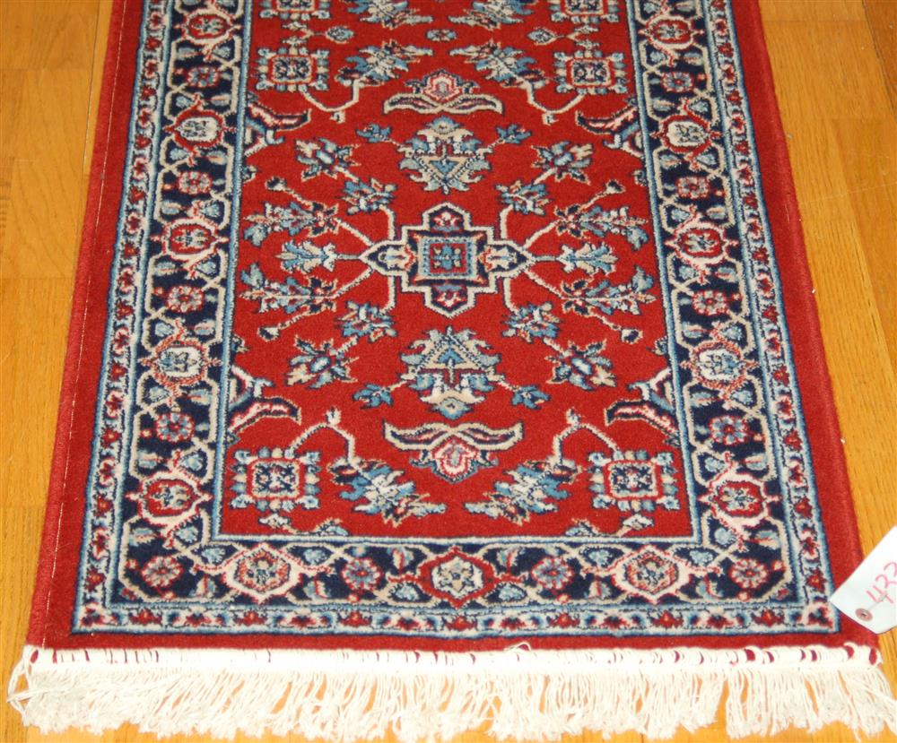 Appraisal: MACHINE MADE WOOL RUG having a geometric pattern red field