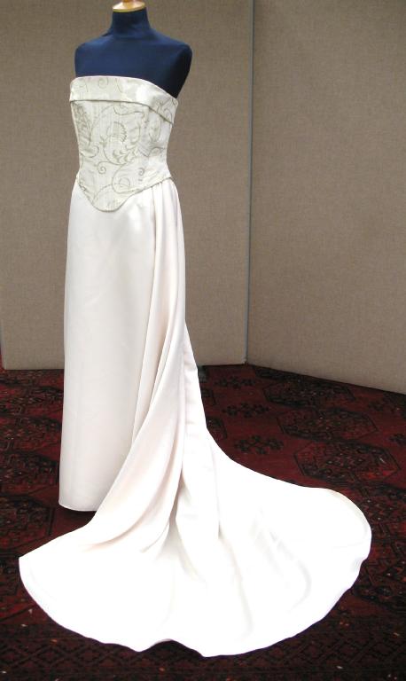 Appraisal: A full length cream satin wedding skirt falling into a