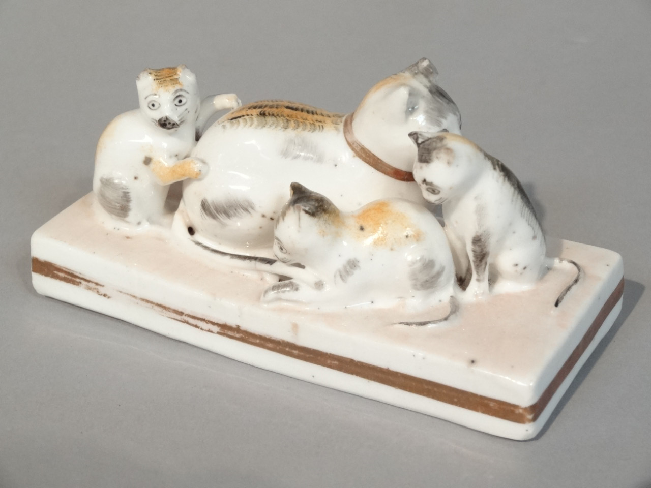 Appraisal: A thC Rockingham style porcelain figure group of a cat