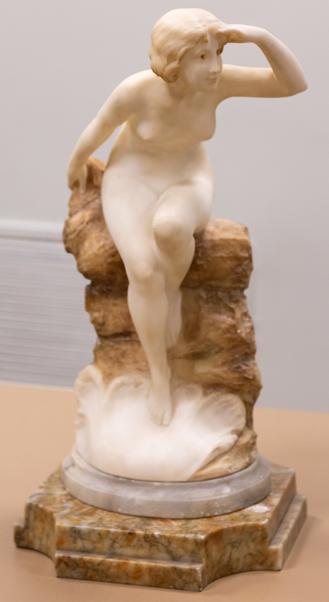 Appraisal: ALABASTER SCULPTURE OF WOMAN PERCHED ON ROCK Early th century