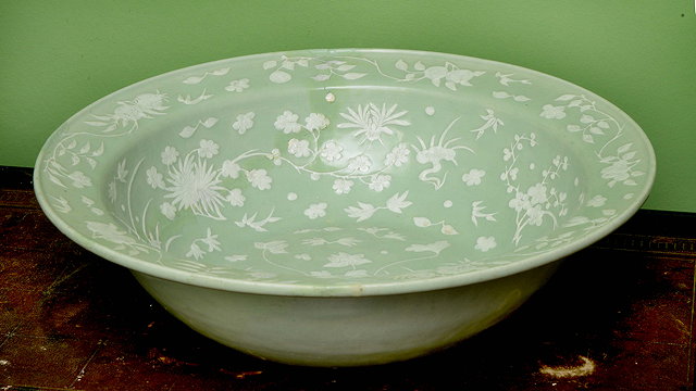 Appraisal: A CHINESE CELADON GLAZED BOWL decorated in white with flowers