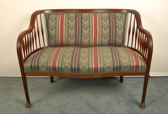 Appraisal: A Mahogany Continuous Arm Settee having spindle sides a stripe