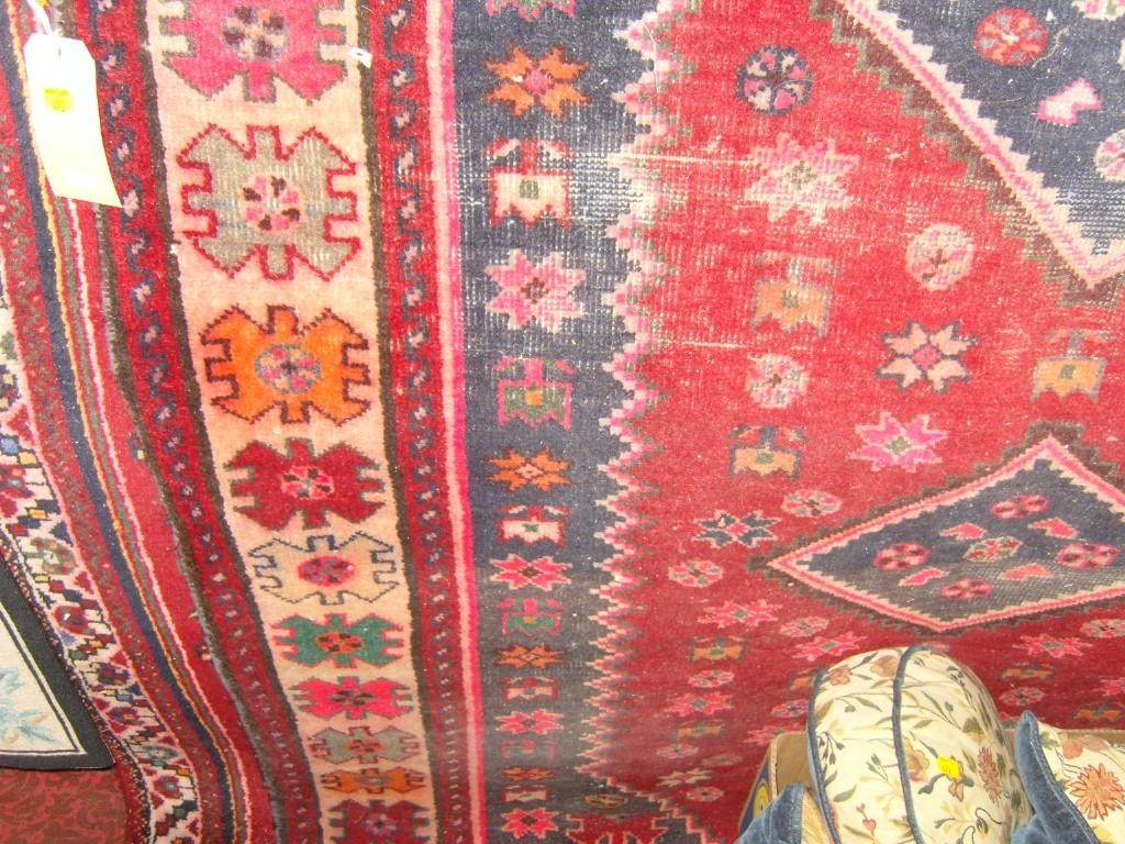 Appraisal: Two red ground eastern wool rugs with geometric and stylised