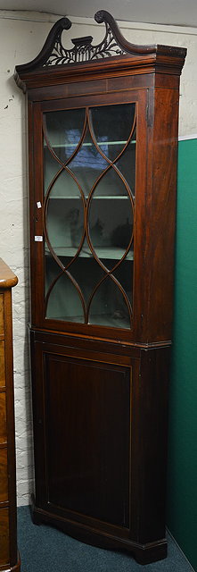 Appraisal: A th Century mahogany corner cabinetwith pierced swan-neck cornice and